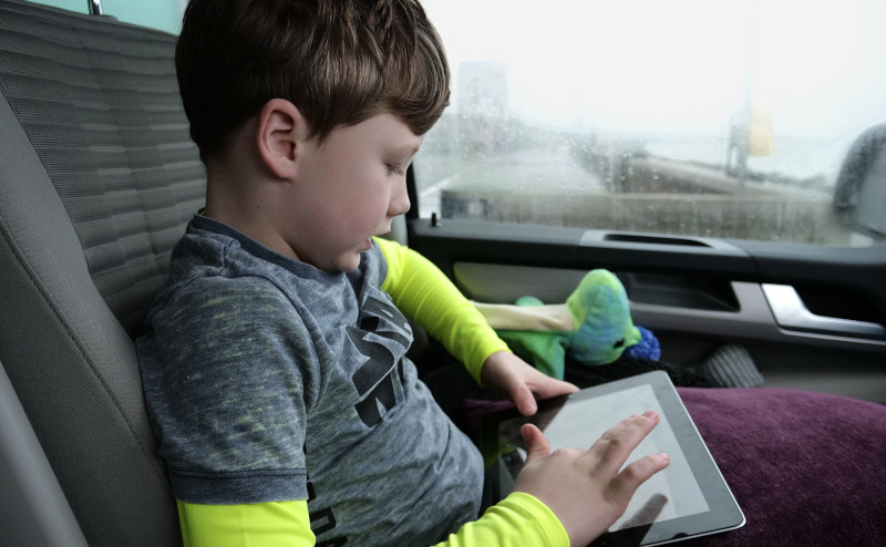 boy playing with ipad during travel
