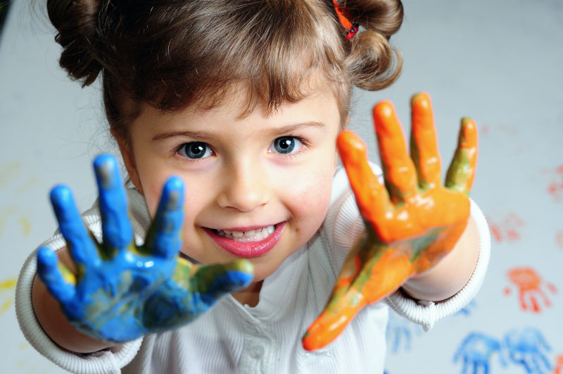 child with color paint on both hands