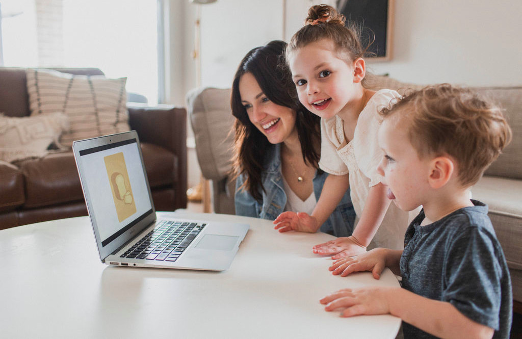 parent teaching her children on laptop