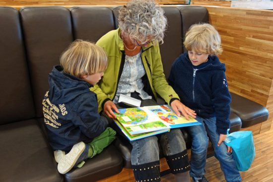 woman reading book to young children